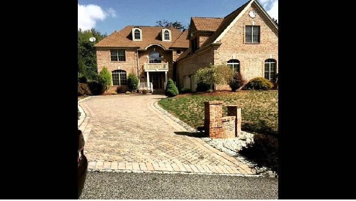 Juelz Sanata brown colored house made of brick with a long entry pathway